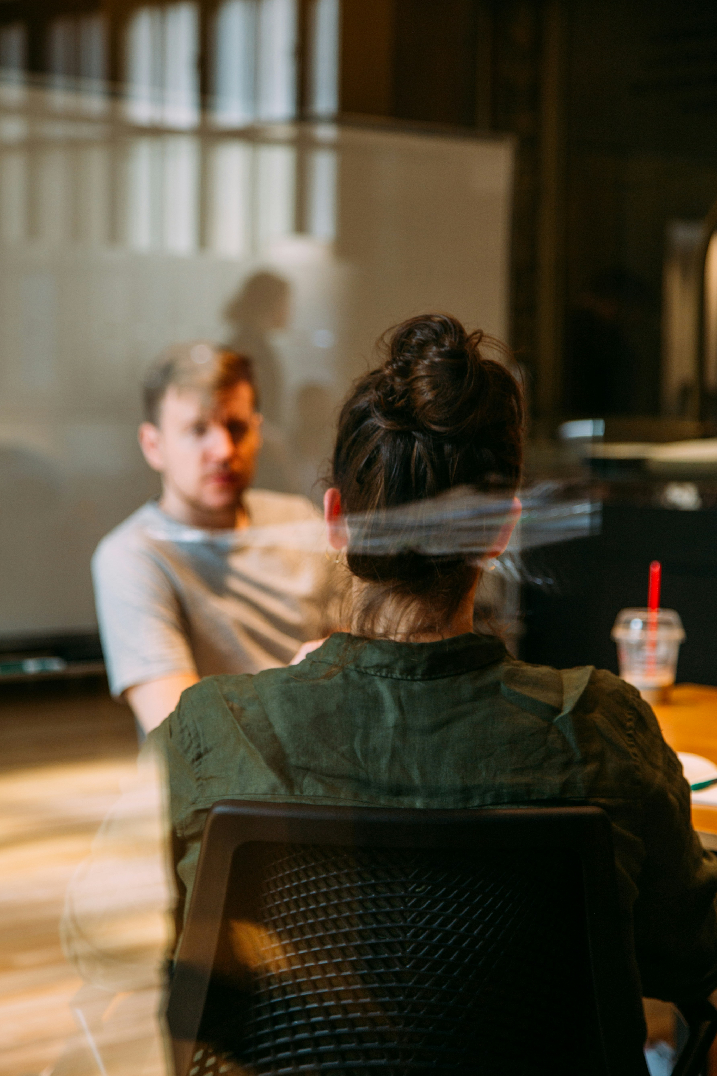 Photo of two women and a man talking in the corner of a room with modern furniture.